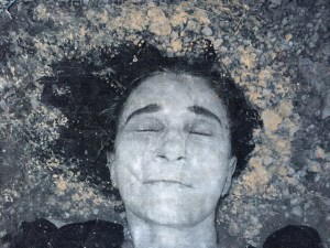 Image a woman, eyes closed, under water with hair flowing out with the current.